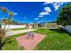 Inviting backyard with green lawn, brick patio, shed, and a charming outdoor seating area at 3303 W Idlewild Ave, Tampa, FL 33614