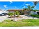 Charming single-story home features a well-manicured lawn and tropical landscaping at 3303 W Idlewild Ave, Tampa, FL 33614