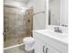Modern bathroom featuring a glass shower, neutral tile, white sink with cabinet, and brushed nickel fixtures at 3807 W Cleveland St, Tampa, FL 33609