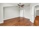 Spacious bedroom features wood flooring, neutral paint, white trim, a ceiling fan, and open access to a hallway at 3807 W Cleveland St, Tampa, FL 33609