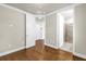 Open bedroom leading to the bathroom boasts hardwood floors, neutral paint, white doors, and an entrance to the Primary bath at 3807 W Cleveland St, Tampa, FL 33609