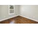 This bedroom features wood flooring, neutral walls, white baseboards, one window, and electrical outlets at 3807 W Cleveland St, Tampa, FL 33609