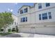 View of three-story white townhomes with two-car garages at 3807 W Cleveland St, Tampa, FL 33609