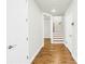 Hallway view featuring wood flooring, neutral walls, white doors, and a staircase with carpeted steps and wood trim at 3807 W Cleveland St, Tampa, FL 33609