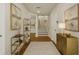 Inviting hallway with hardwood floors, stylish gold shelving, artwork, and staircase leading to the upper level at 3807 W Cleveland St, Tampa, FL 33609
