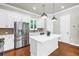 Modern kitchen featuring stainless steel appliances, white cabinets, an island, and wood flooring at 3807 W Cleveland St, Tampa, FL 33609
