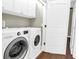 Functional laundry room with modern washer and dryer, and overhead cabinets for storage and organization at 3807 W Cleveland St, Tampa, FL 33609