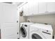 Practical laundry area featuring side-by-side appliances and ample storage in overhead cabinets at 3807 W Cleveland St, Tampa, FL 33609