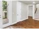 Bright living area features wood floors, neutral walls, a door to the outside and entrances to a hallway and stairs at 3807 W Cleveland St, Tampa, FL 33609