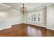 Sun-filled living room featuring hardwood floors, lots of natural light, and an elegant decorative chandelier at 3807 W Cleveland St, Tampa, FL 33609