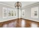 Sun-filled living room featuring hardwood floors, lots of natural light, and an elegant decorative chandelier at 3807 W Cleveland St, Tampa, FL 33609