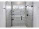 Modern tiled shower with glass door, rainfall showerhead, and built-in shelving for added convenience at 3807 W Cleveland St, Tampa, FL 33609