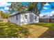 Back exterior view of a house showcasing a fenced yard with a well-maintained lawn at 403 E North St, Tampa, FL 33604