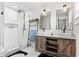 Bright bathroom featuring double sink vanity, walk-in shower with black hardware, and modern fixtures at 403 E North St, Tampa, FL 33604