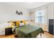 Bright bedroom featuring wood floors, warm yellow and green accents, and a window with coverings at 403 E North St, Tampa, FL 33604