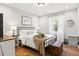 Cozy bedroom featuring hardwood floors, black metal bed frame, and natural lighting at 403 E North St, Tampa, FL 33604