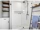 Close up of a modern shower with glass enclosure and black hardware with shelving storage at 403 E North St, Tampa, FL 33604