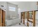 Bathroom is under construction with white tile, window, tub, toilet, and gray tile floor at 4101 Shore Acres Ne Blvd, St Petersburg, FL 33703