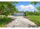 Single-story home with a gray exterior, an attached garage and a large concrete driveway at 4101 Shore Acres Ne Blvd, St Petersburg, FL 33703