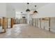 Open-concept kitchen features modern pendant lighting, white cabinetry, and exposed framing at 4101 Shore Acres Ne Blvd, St Petersburg, FL 33703