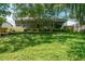 Exterior view of a brick home with screened patio and a large backyard at 4167 Seton Cir, Palm Harbor, FL 34683