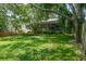 Landscaped backyard features a brick home, screened patio, and wood fencing at 4167 Seton Cir, Palm Harbor, FL 34683