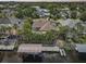 An aerial shot of a waterfront house featuring a private dock, lush landscaping, and solar panels on the roof at 4615 Shark Dr, Bradenton, FL 34208