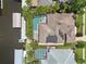 An aerial view showcases the home with a screened pool, solar panels, and boat dock on the water at 4615 Shark Dr, Bradenton, FL 34208