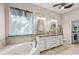 Bright bathroom featuring a tub, dual sinks, and tile floors at 4615 Shark Dr, Bradenton, FL 34208