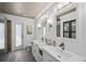 Bright bathroom featuring dual vanities, wood-like flooring, and white wainscoting at 4615 Shark Dr, Bradenton, FL 34208