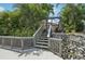 Picturesque waterfront with stairs leading from the dock to the property, surrounded by lush greenery at 4615 Shark Dr, Bradenton, FL 34208