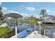 Waterfront view of a dock with boat lift and a kayak, nestled among lush tropical vegetation at 4615 Shark Dr, Bradenton, FL 34208