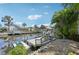Scenic waterfront view featuring a private dock with boat lift and lush tropical landscaping at 4615 Shark Dr, Bradenton, FL 34208