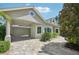 Home exterior featuring a porte cochere, a two-car garage, a paver driveway, and lush landscaping at 4615 Shark Dr, Bradenton, FL 34208