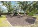 A community playground featuring multiple slides and play structures, surrounded by trees and greenery at 4615 Shark Dr, Bradenton, FL 34208