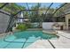 Screened pool with a spa, a built-in grill area, and tropical landscaping for a luxurious outdoor experience at 4615 Shark Dr, Bradenton, FL 34208