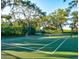 A well-maintained tennis court with lush green surroundings and mature trees draped with Spanish moss at 4615 Shark Dr, Bradenton, FL 34208