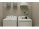 Functional laundry room showcasing front load washer and dryer with storage shelves and decorative accents at 4765 Southern Valley Loop, Brooksville, FL 34601