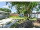 Lush backyard with mature trees, a shed, and a paved patio area, perfect for outdoor living at 4917 99Th N St, St Petersburg, FL 33708
