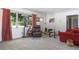 Sunlit living room featuring comfortable seating, with views of the front yard through large windows at 4917 99Th N St, St Petersburg, FL 33708