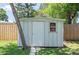 A backyard storage shed with a door and window provides secure outdoor storage for tools and equipment, plus a path to access at 4917 99Th N St, St Petersburg, FL 33708