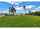 Beautiful backyard with a scenic water view, lush green grass, and several palms at 500 N Osceola Ave # 211, Clearwater, FL 33755