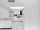 Bright white kitchen with an island, appliances, and contrasting dark countertop and flooring at 500 N Osceola Ave # 211, Clearwater, FL 33755