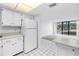 Bright kitchen with white appliances and cabinets adjacent to the living area at 500 N Osceola Ave # 211, Clearwater, FL 33755