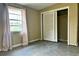 An average-sized bedroom featuring neutral walls, gray floors, a window, and a closet with sliding doors at 5016 S 86Th St, Tampa, FL 33619