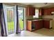 An efficiently designed kitchen has wood cabinets, tiled floors, and a sliding glass door to the backyard at 5016 S 86Th St, Tampa, FL 33619