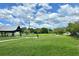 Open green space with shelter, and walking path under a sunny sky with fluffy clouds at 5016 S 86Th St, Tampa, FL 33619