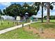 Community park with playground, swings, and picnic area, near sidewalk and mature trees at 5016 S 86Th St, Tampa, FL 33619
