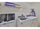 This laundry room features shelving, a washer and dryer, and television for convenience at 5438 Summer Sunset Dr, Apollo Beach, FL 33572
