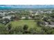 Aerial view of a community park surrounded by lush greenery and streets lined with colorful buildings on a sunny day at 5918 Beaconpark St, Lithia, FL 33547